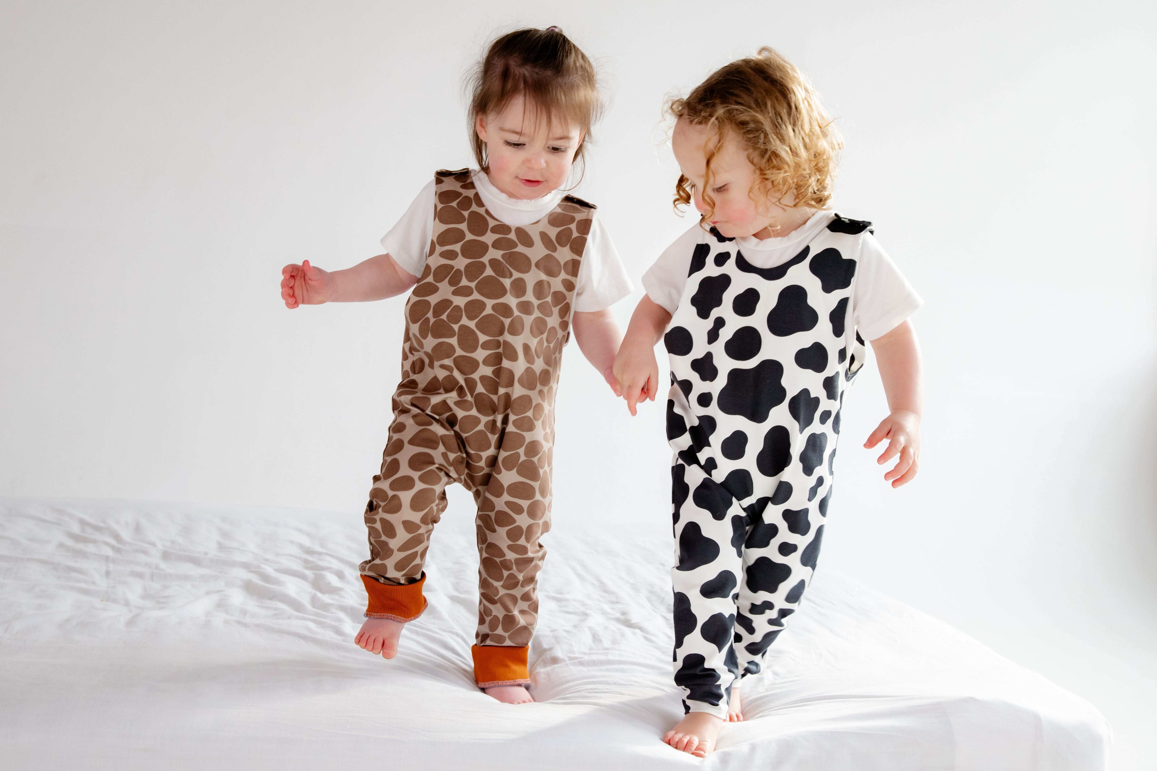 Cute duo in matching animal rompers, both cow and giraffe prints are simple yet bold. Rompers perfect for running and climbing, just being a toddler.