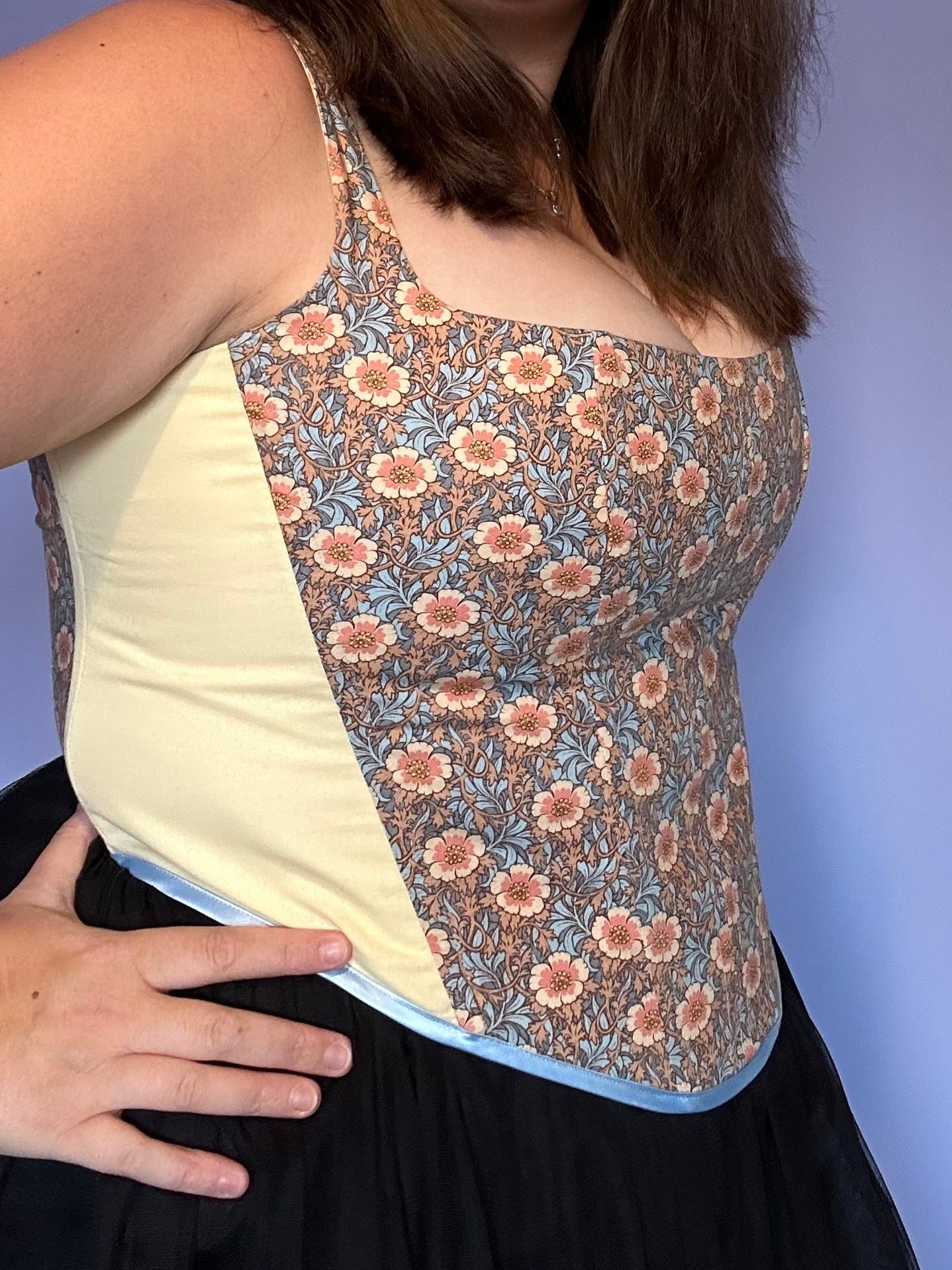 Handmade boned corset featuring a vintage floral print with soft cream side panels. Designed for both comfort and style, this unique piece blends classic craftsmanship with modern elegance.