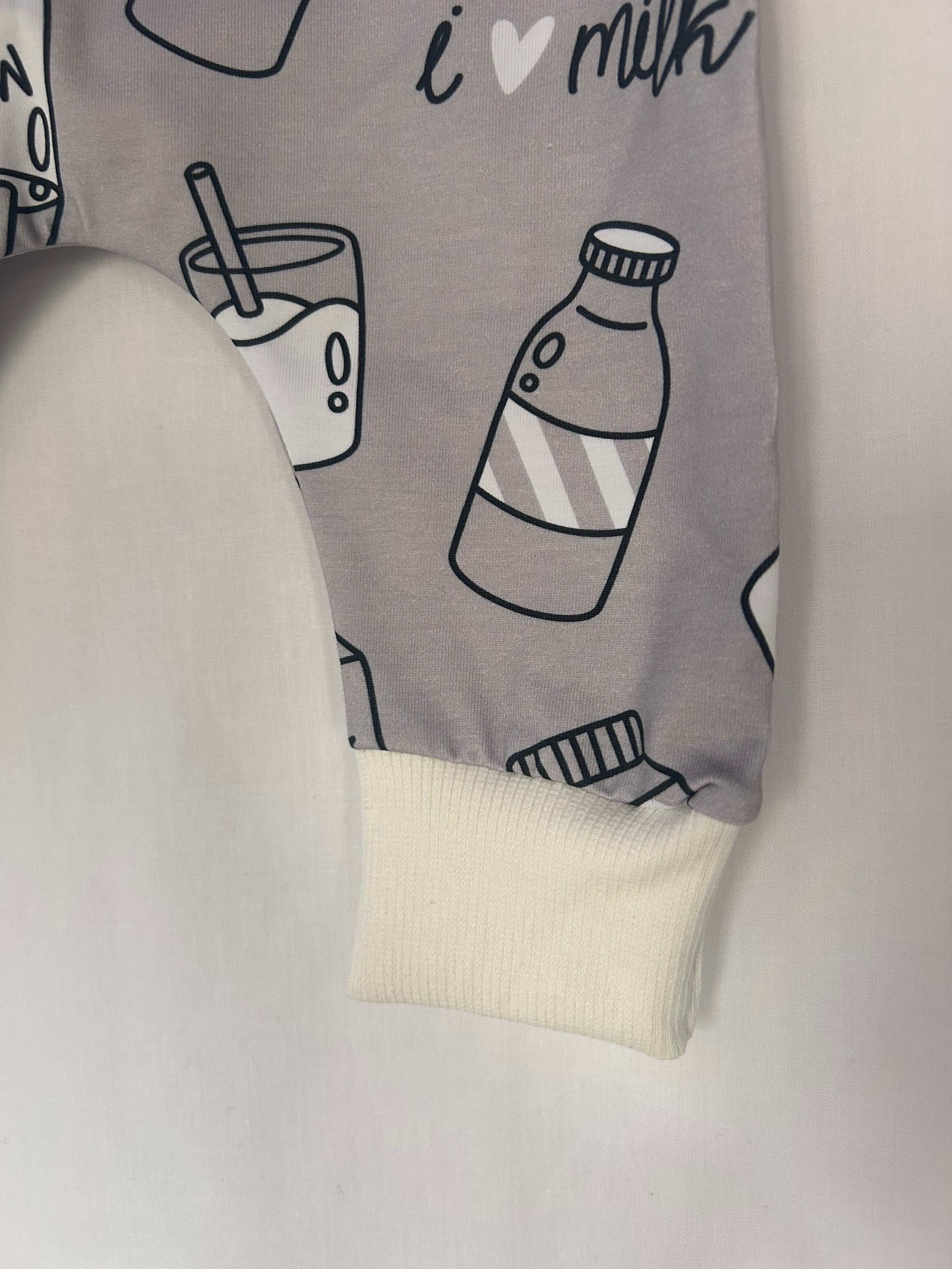 Monotone I Love Milk romper handmade for babies and toddlers, fun for running, jumping and climbing. Dungarees style outfit in a stretchy cotton fabric handmade in Oxfordshire.