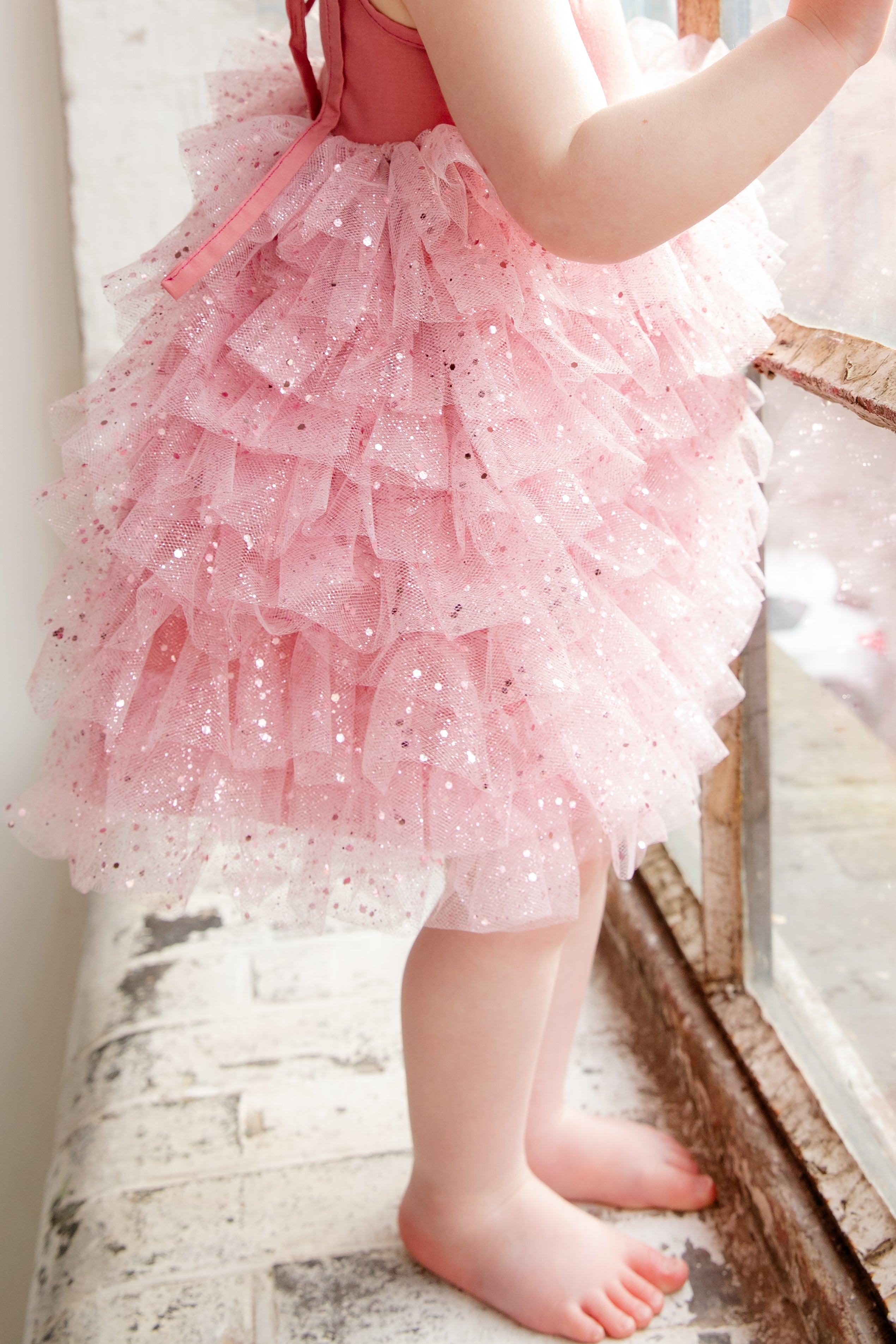 This handmade bespoke dress dazzles with layers of soft tulle, delicate sparkles, and a fitted bodice. Perfect for birthdays, photoshoots or fairy tale adventures.