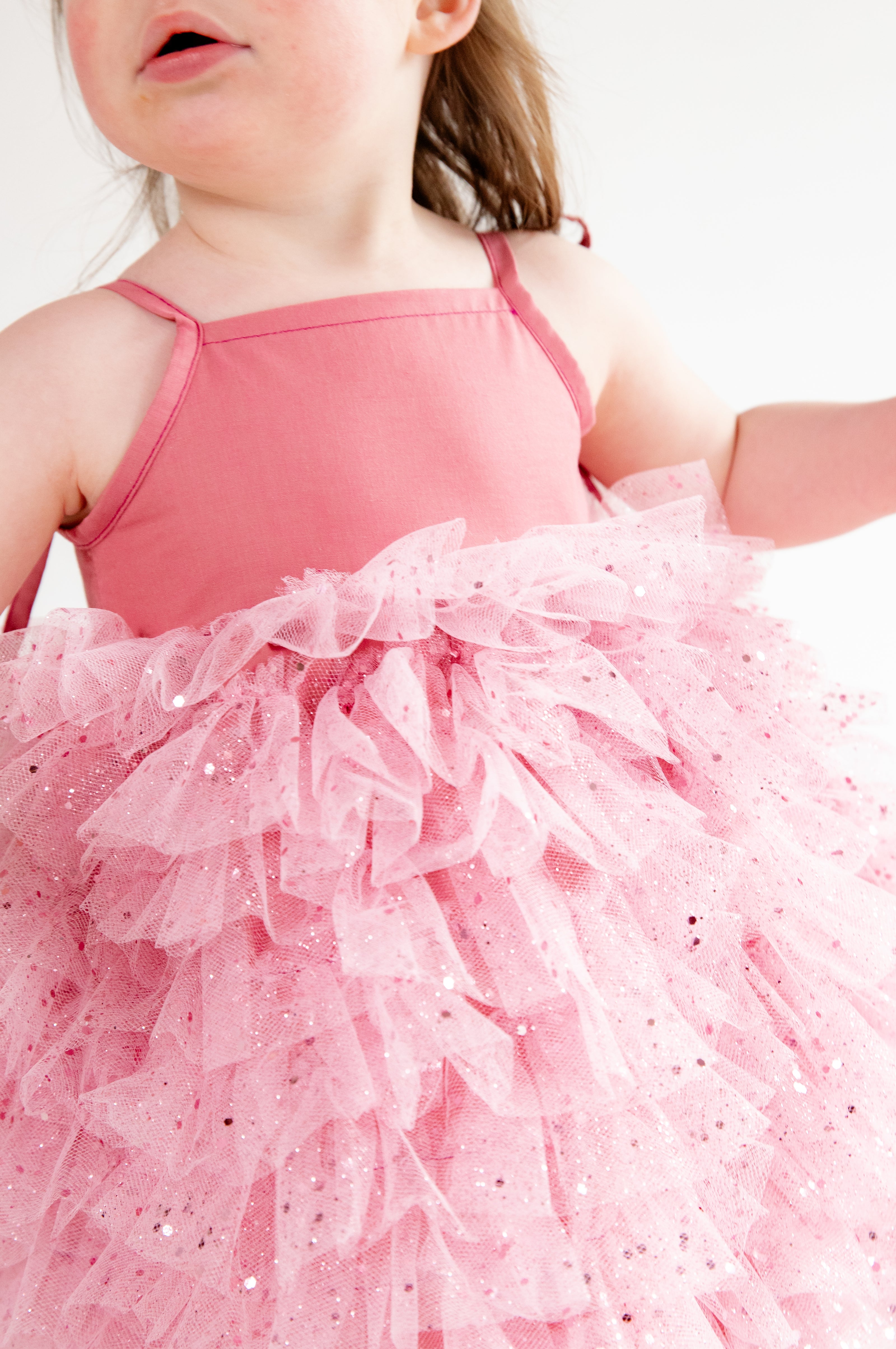 This handmade bespoke dress dazzles with layers of soft tulle, delicate sparkles, and a fitted bodice. Perfect for birthdays, photoshoots or fairy tale adventures.