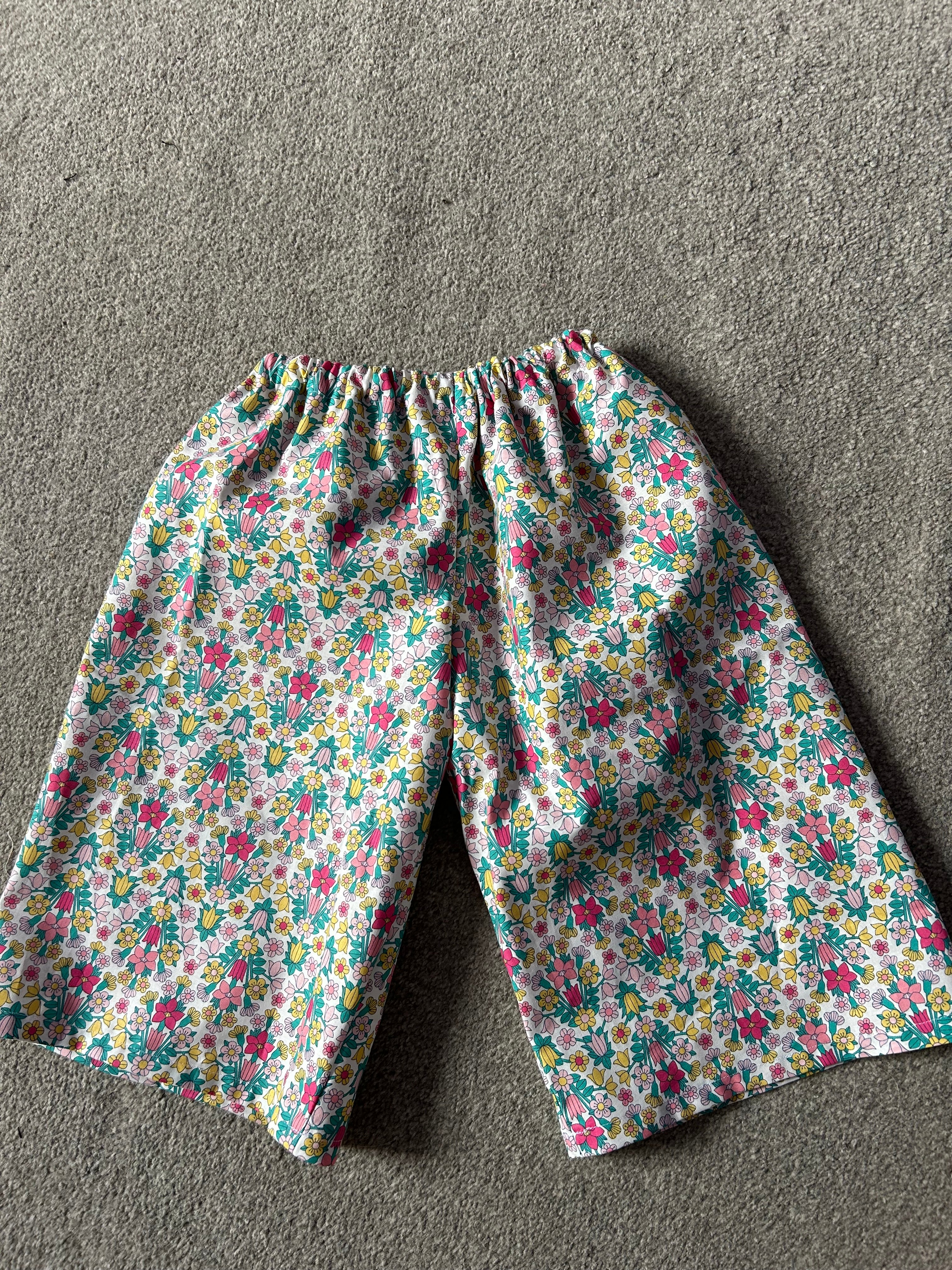 Handmade cotton trousers with a vibrant floral print, featuring a comfy elastic waistband. Lightweight, breathable and perfect for playful summer wear.