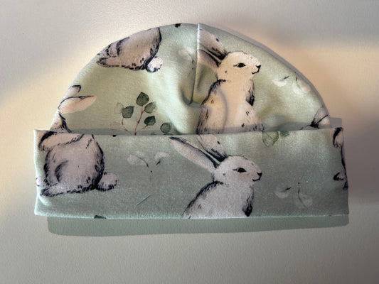 Baby hat with green bunnies pattern, handmade in Oxfordshire