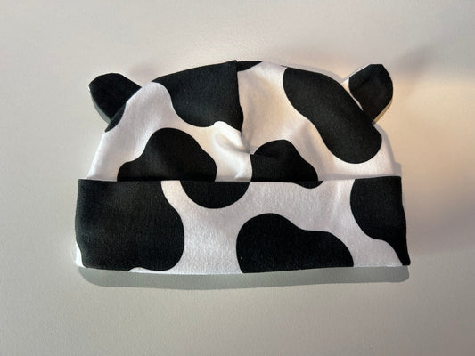Baby hat with bold cow pattern, handmade in Oxfordshire