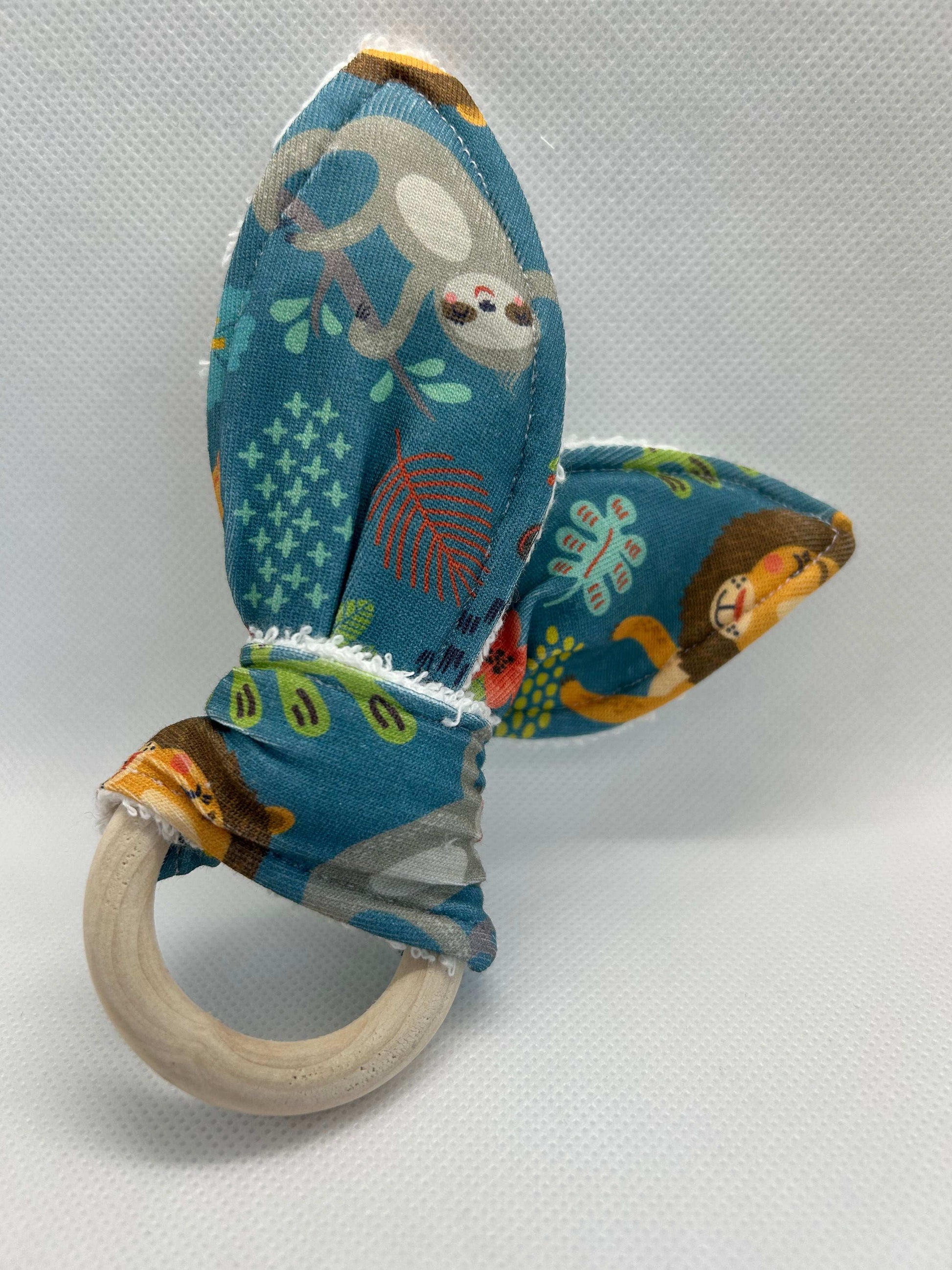 Baby rattle toy made from a baby safe soft jersey cotton and cotton towelling. A stimulating rattle in one side and crinkle paper in the other making very interactive, wrapped around a teething ring for safe chewing!