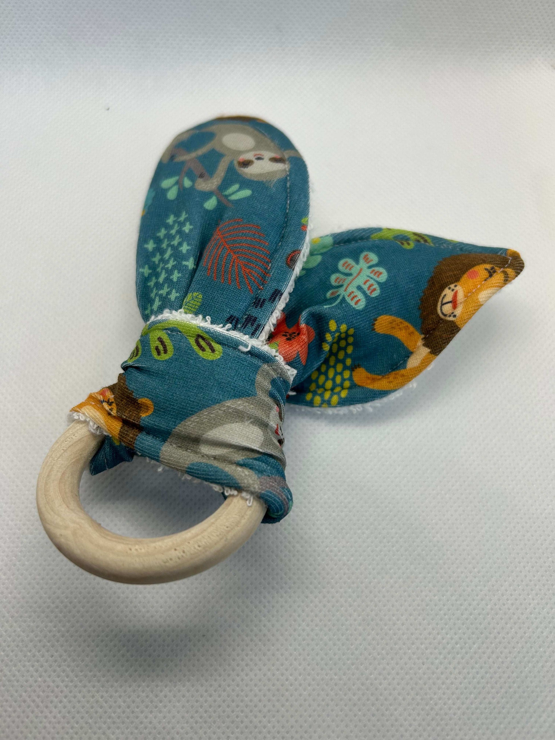 Baby rattle toy made from a baby safe soft jersey cotton and cotton towelling. A stimulating rattle in one side and crinkle paper in the other making very interactive, wrapped around a teething ring for safe chewing!