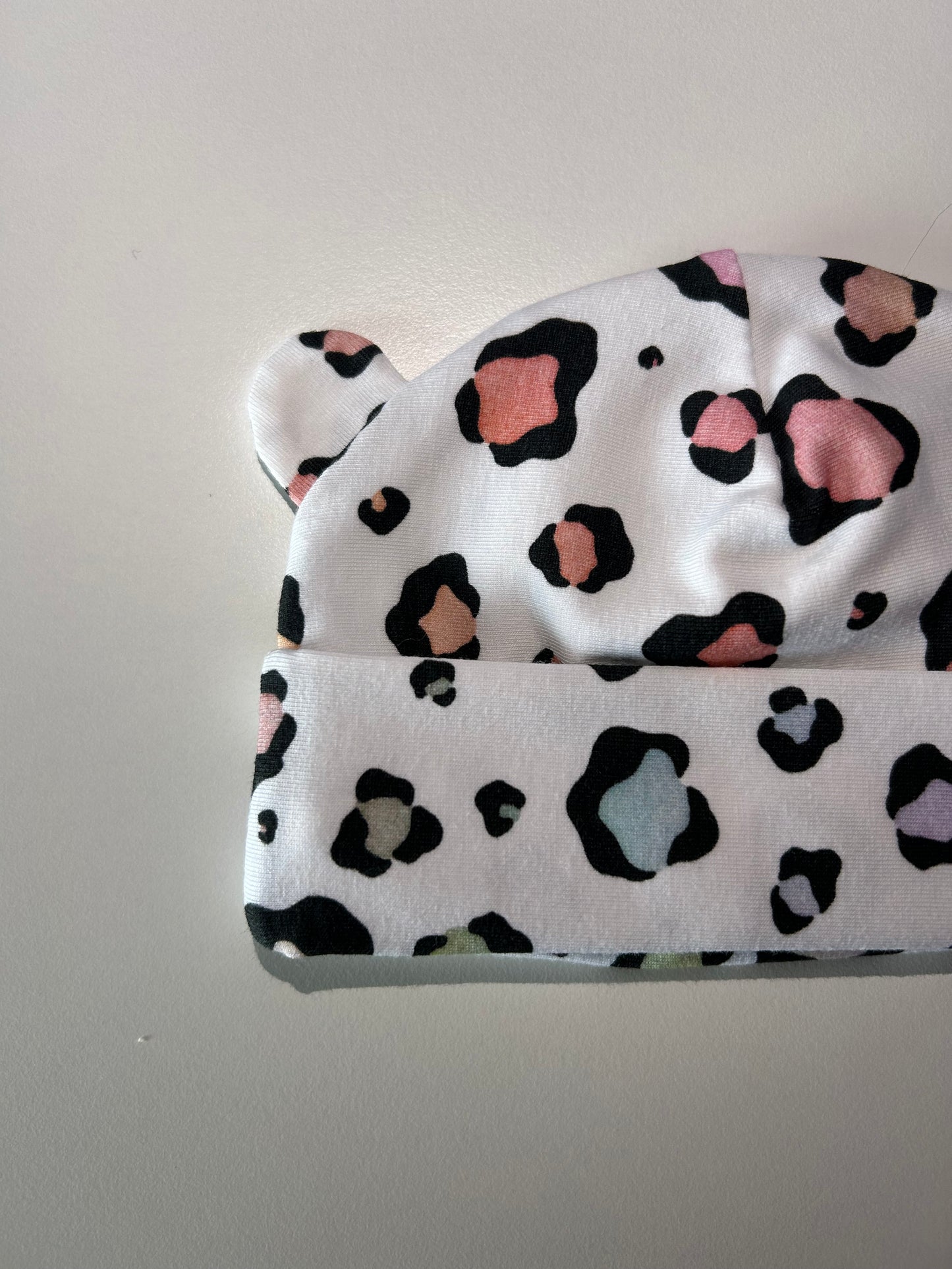 Baby hat with pastel leopard pattern, handmade in Oxfordshire