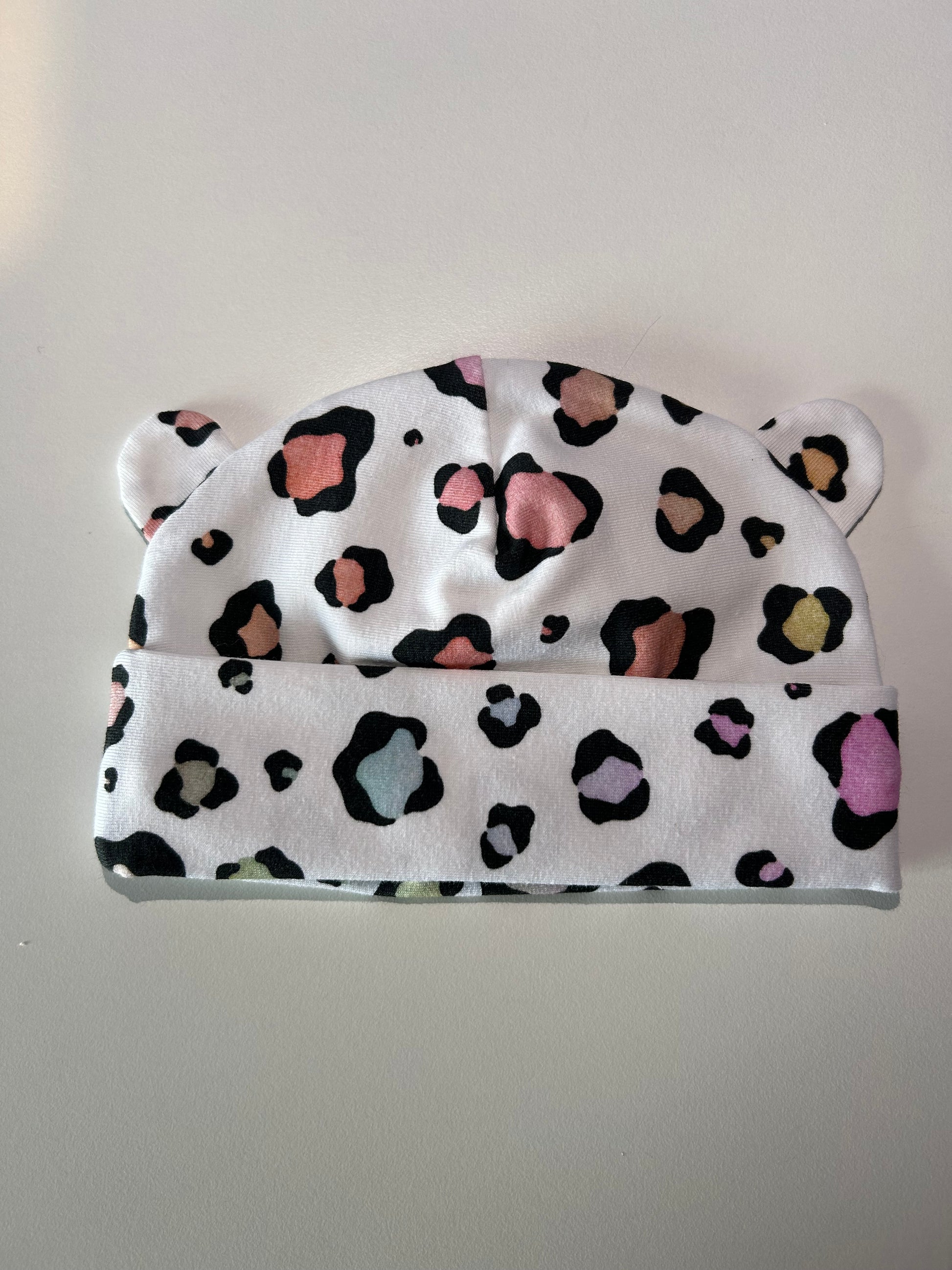 Baby hat with pastel leopard pattern, handmade in Oxfordshire