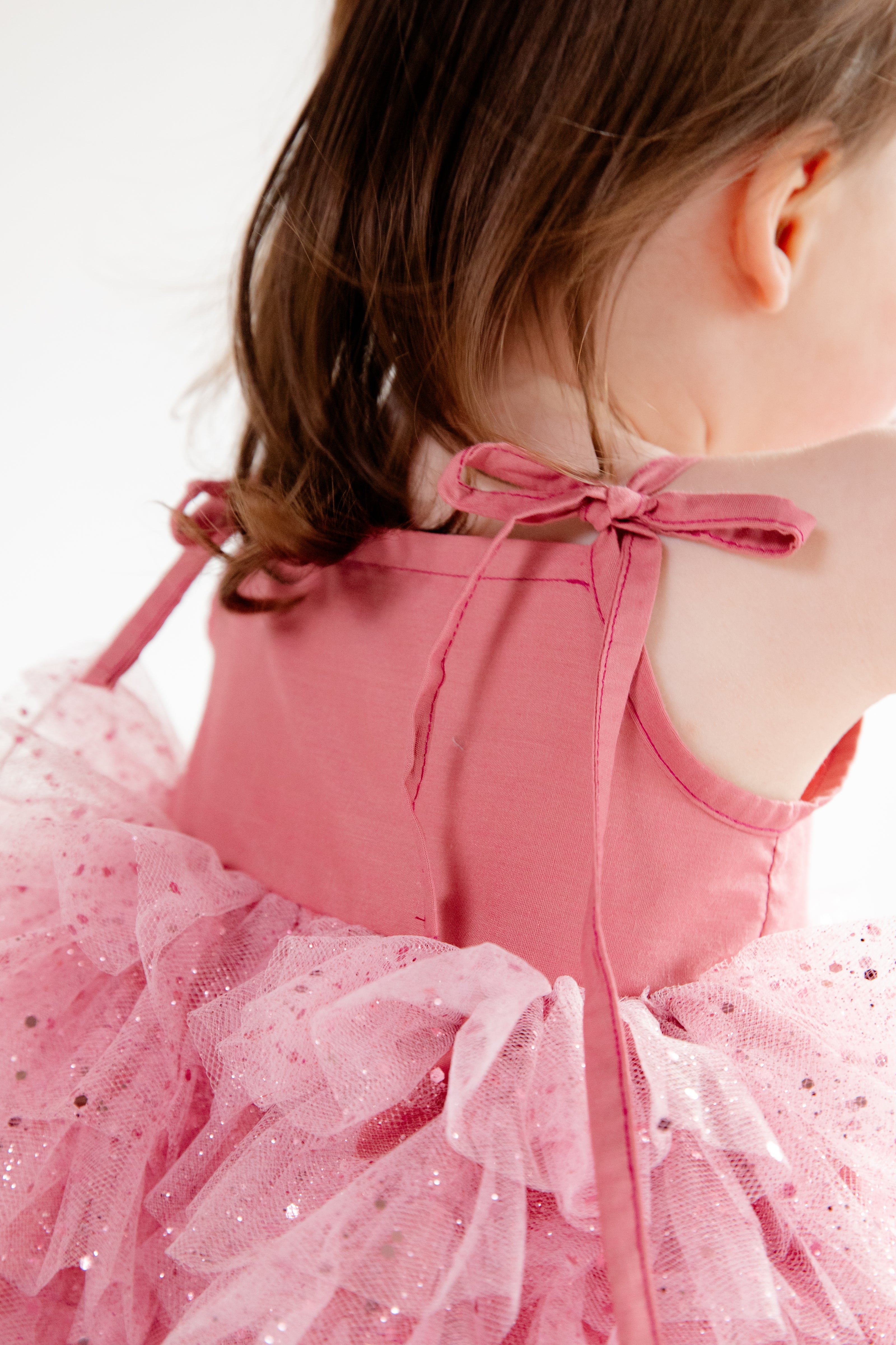 This handmade bespoke dress dazzles with layers of soft tulle, delicate sparkles, and a fitted bodice. Perfect for birthdays, photoshoots or fairy tale adventures.