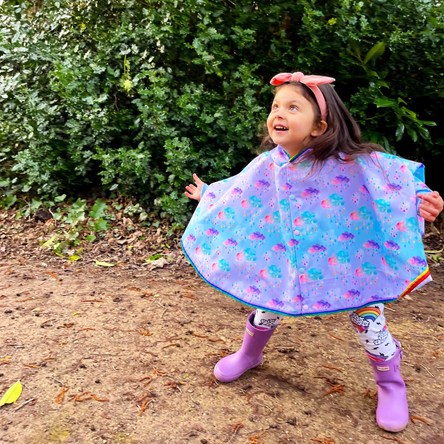 Keep little adventurers dry in style with this handmade waterproof cape, featuring a playful umbrella print, rainbow trim and roomy fit for carefree outdoor fun in any weather.