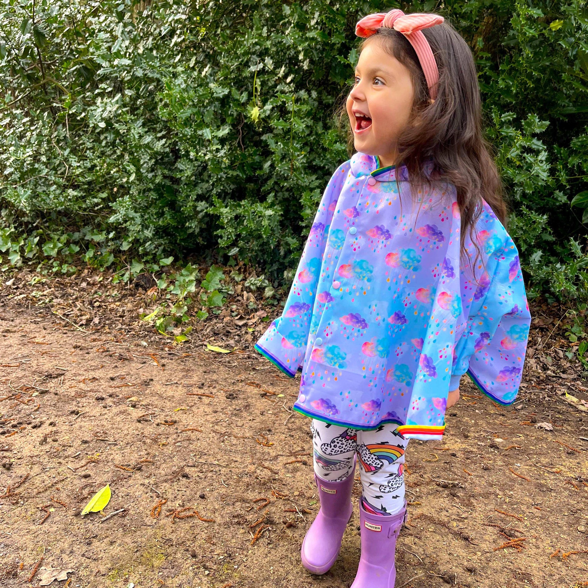 Keep little adventurers dry in style with this handmade waterproof cape, featuring a playful umbrella print, rainbow trim and roomy fit for carefree outdoor fun in any weather.