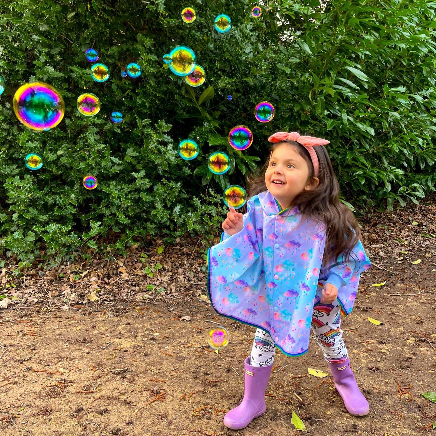 Keep little adventurers dry in style with this handmade waterproof cape, featuring a playful umbrella print, rainbow trim and roomy fit for carefree outdoor fun in any weather.