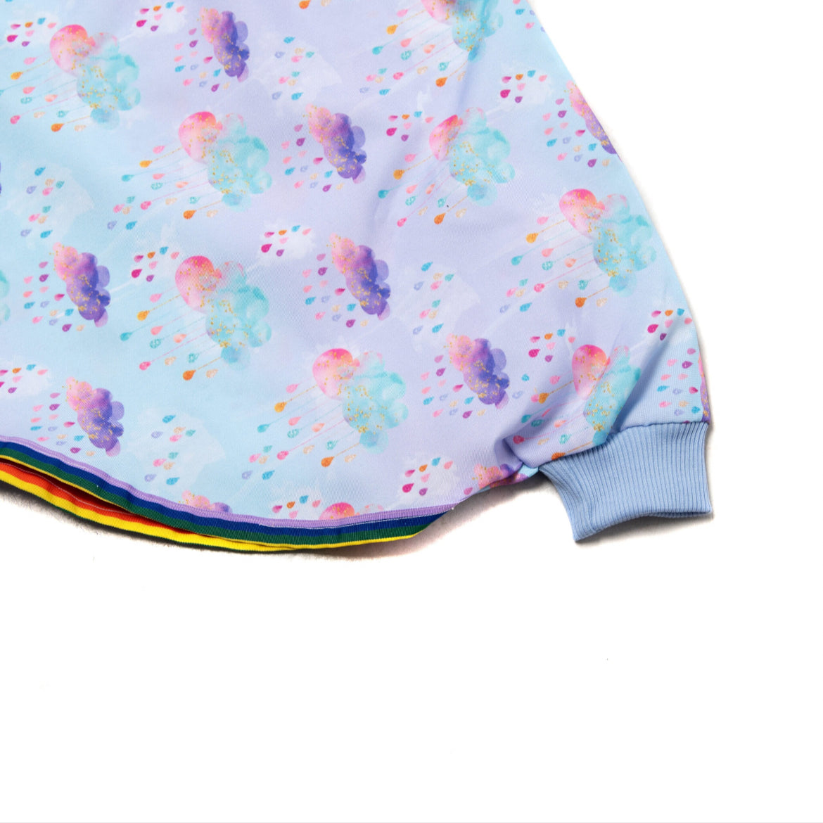 Keep little adventurers dry in style with this handmade waterproof cape, featuring a playful umbrella print, rainbow trim and roomy fit for carefree outdoor fun in any weather.