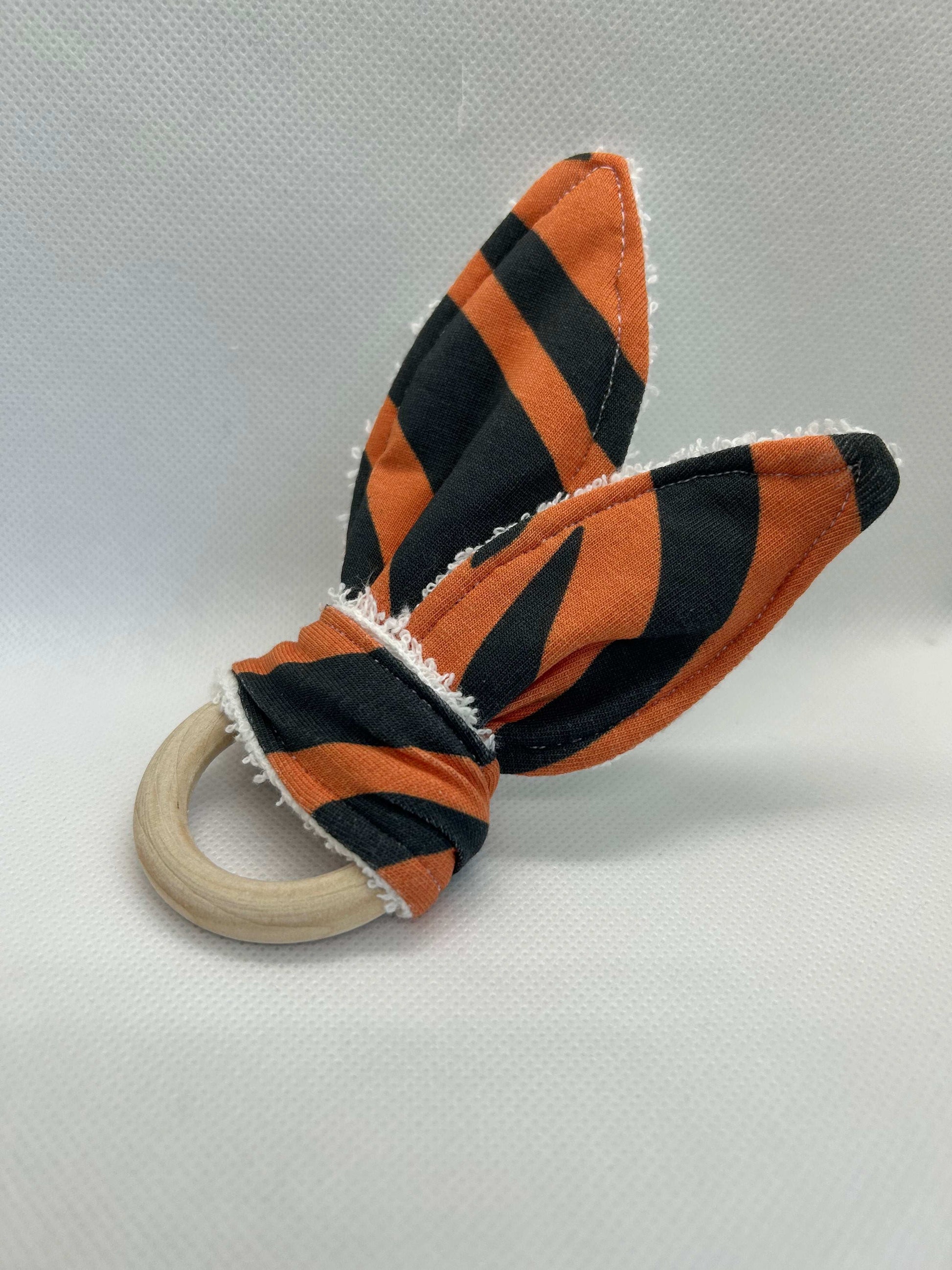 Baby rattle toy made from a baby safe soft jersey cotton and cotton towelling. A stimulating rattle in one side and crinkle paper in the other making very interactive, wrapped around a teething ring for safe chewing!