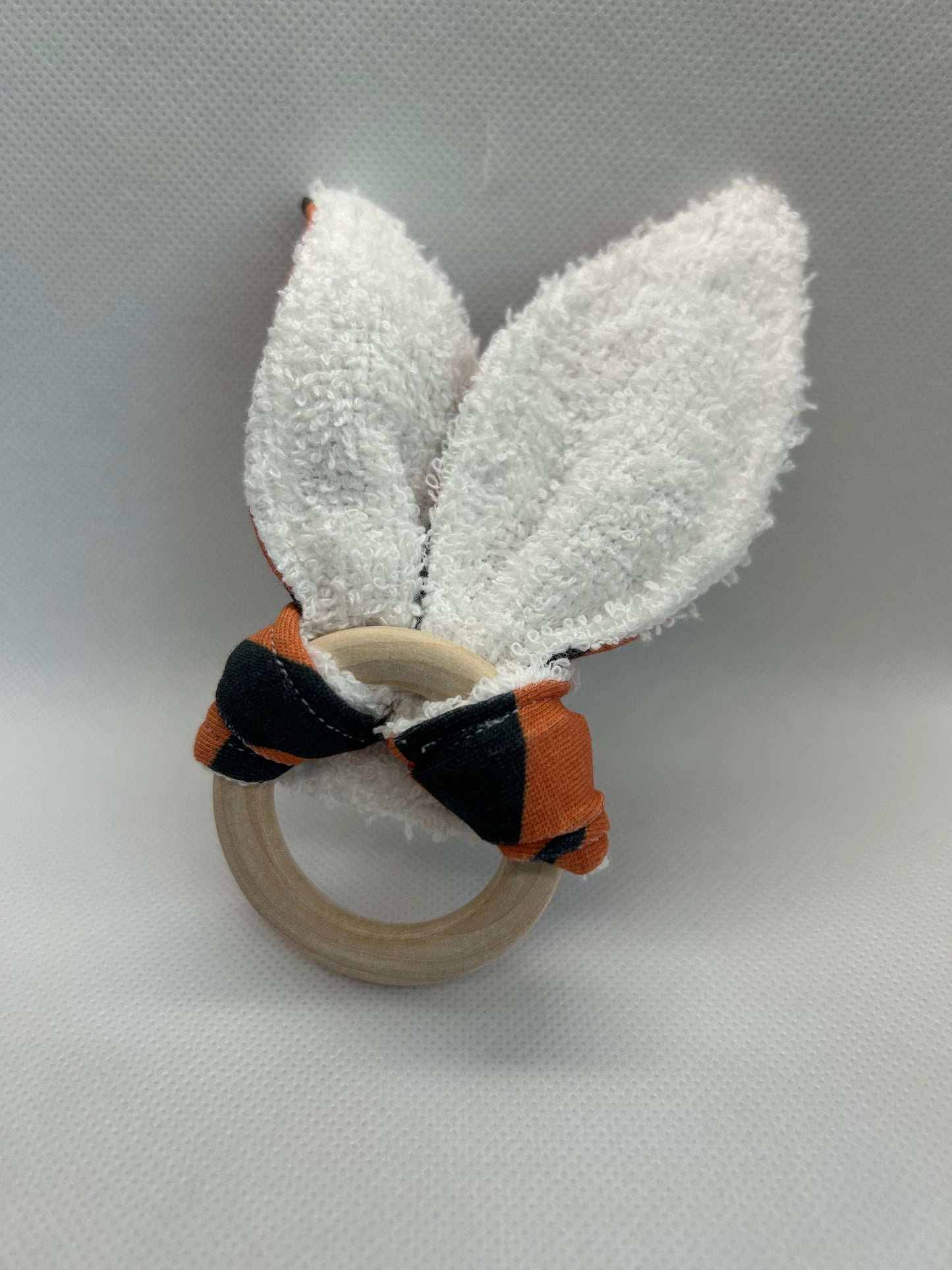 Baby rattle toy made from a baby safe soft jersey cotton and cotton towelling. A stimulating rattle in one side and crinkle paper in the other making very interactive, wrapped around a teething ring for safe chewing!