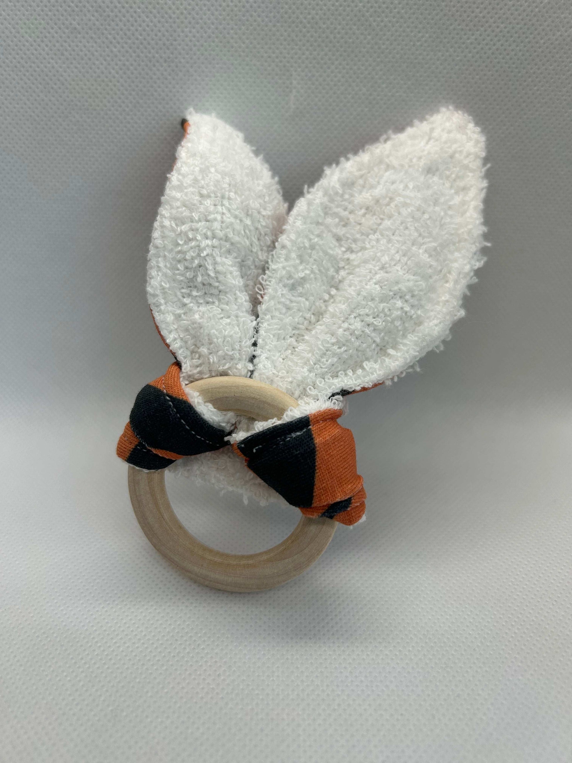 Baby rattle toy made from a baby safe soft jersey cotton and cotton towelling. A stimulating rattle in one side and crinkle paper in the other making very interactive, wrapped around a teething ring for safe chewing!