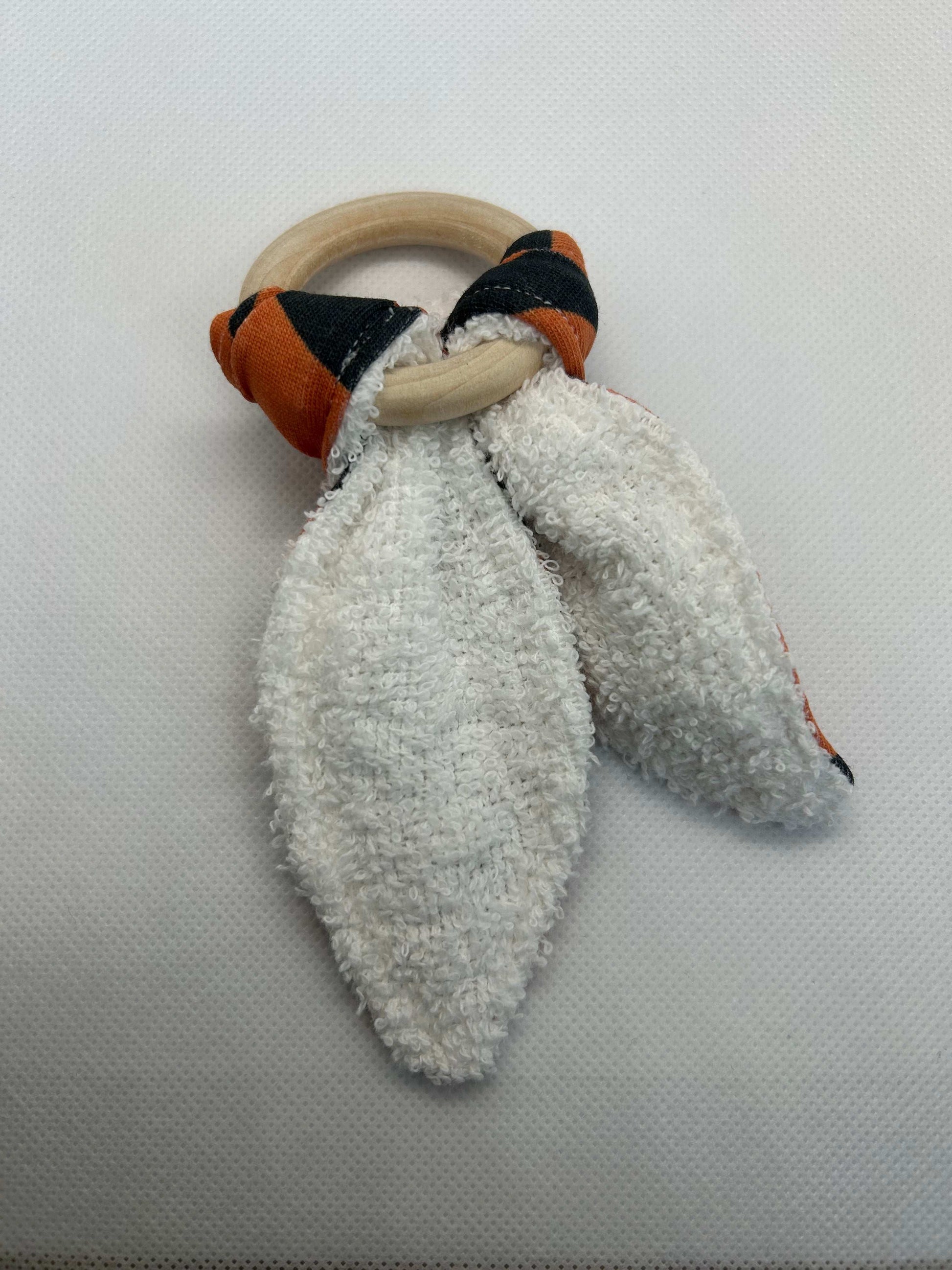 Baby rattle toy made from a baby safe soft jersey cotton and cotton towelling. A stimulating rattle in one side and crinkle paper in the other making very interactive, wrapped around a teething ring for safe chewing!