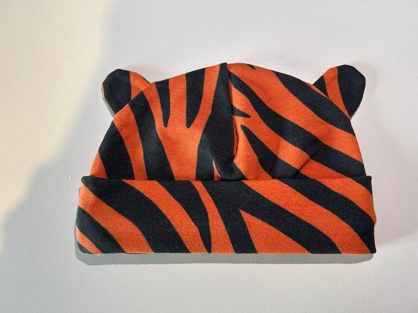Baby hat with bold tiger pattern, handmade in Oxfordshire