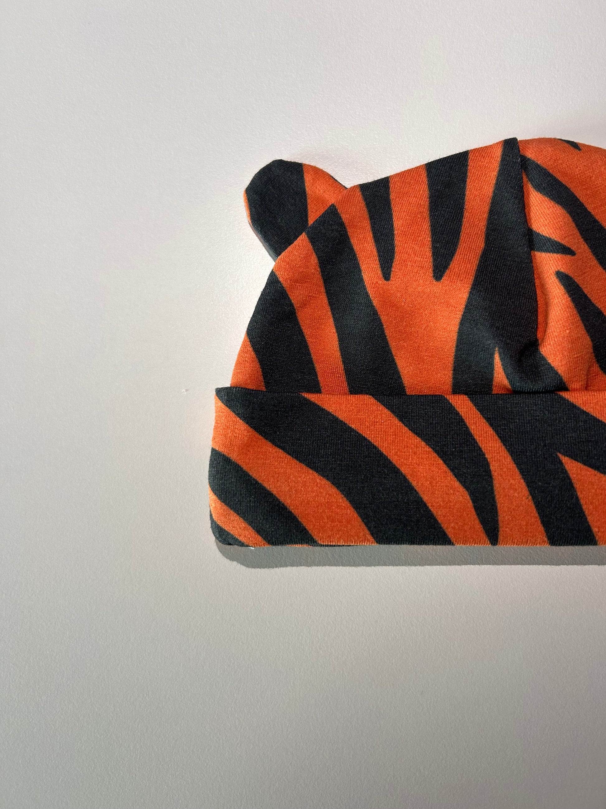 Baby hat with bold tiger pattern, handmade in Oxfordshire