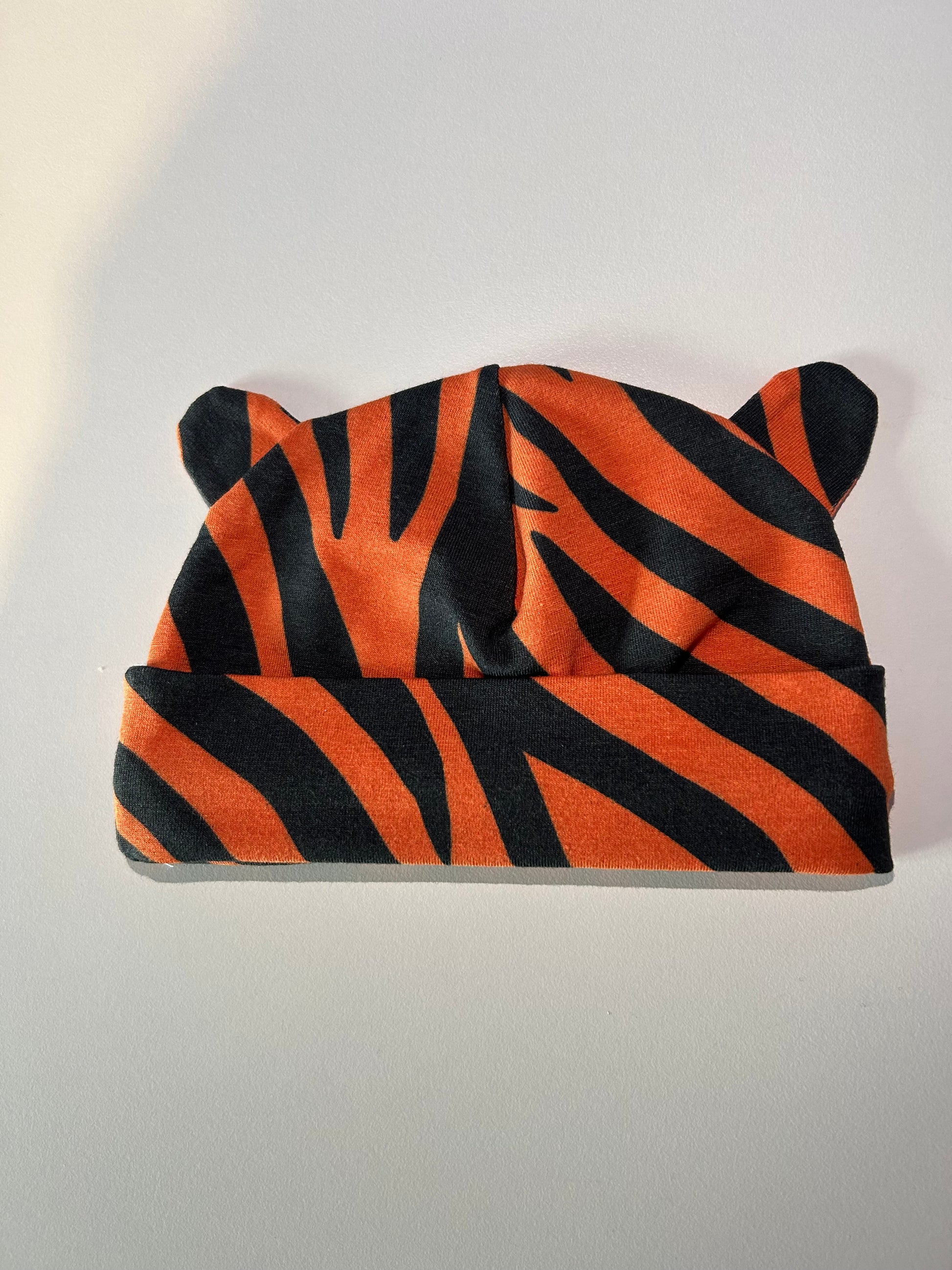 Baby hat with bold tiger pattern, handmade in Oxfordshire